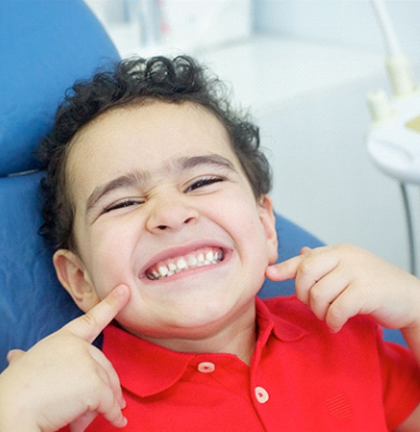 Young boy points to his smile after visiting Braintree dentist 