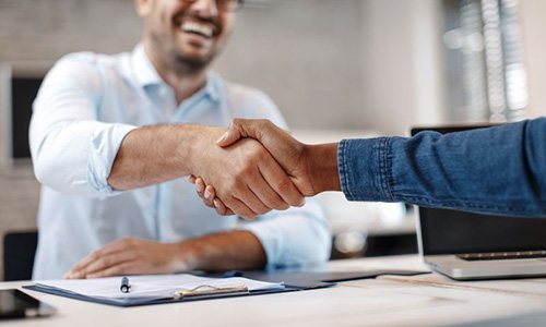 Two men shaking hands in a professional setting