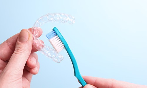 Patient cleaning clear aligner with toothbrush