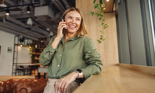 Woman smiling while talking on phone at restaurant