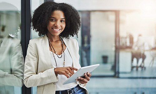 Woman smiling while holding tablet in office